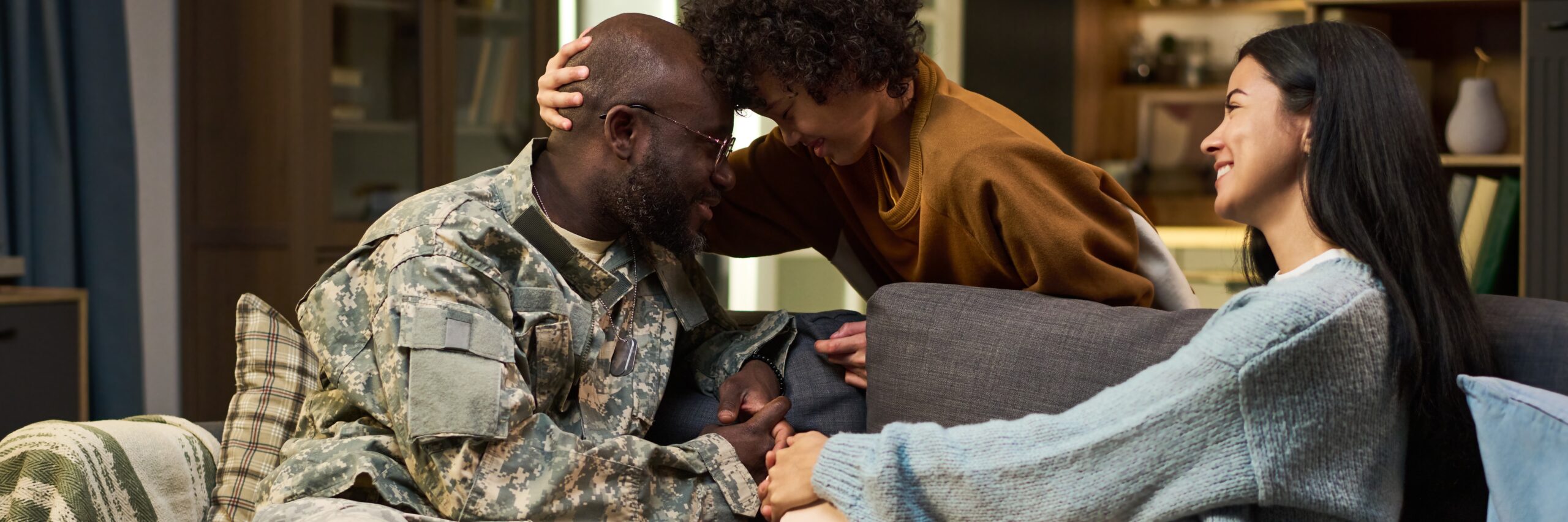 Male veteran embracing family after discussing filing mental health secondary to PACT Act conditions with VMHA